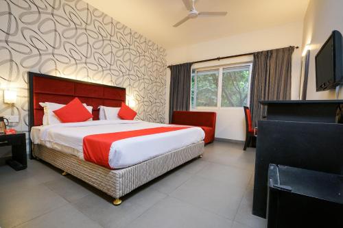 a bedroom with a large bed with red pillows at Townhouse Mookkannoor Tourist Home in Cochin