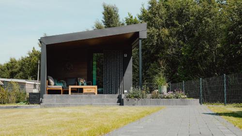 a small building with a table in a yard at Natursee-Chalet, Angeln, Wellness, Spa, Ponyhof in Twist