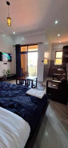 a bedroom with a large bed and a living room at CALM STAYs in Kampala