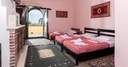 two beds in a room with a fireplace at Arolithos Traditional Village Hotel in Tílisos