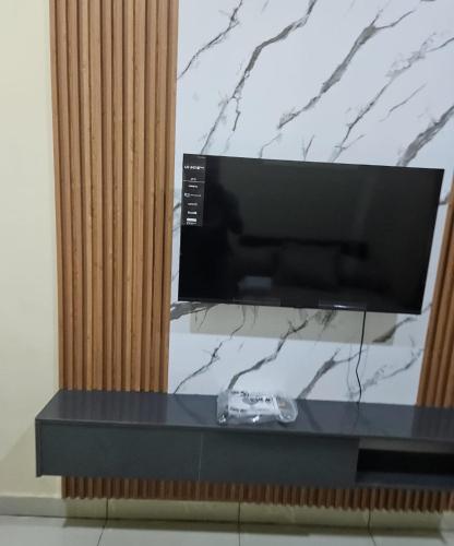 a flat screen tv sitting on top of a counter at Wood Lake Apartment in Dushekoro
