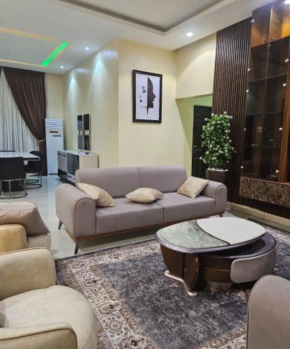 a living room with a couch and a table at Wood Lake Apartment in Dushekoro