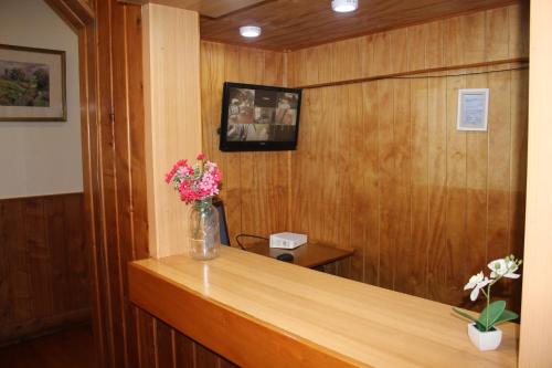 a room with a counter with a vase of flowers on it at Hotel Casona Freire in Puerto Varas
