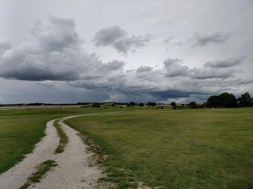 a dirt road in a field under a cloudy sky at 4 star holiday home in VISBY in Visby