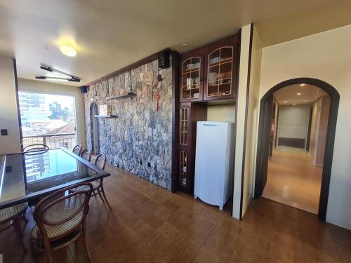 a dining room with a table and a refrigerator at Apartamento ao lado do Shopping Lamérica in Bento Gonçalves
