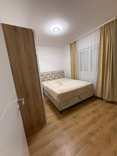 a bedroom with a bed in a room with a window at Dream Casa in Banja Koviljača