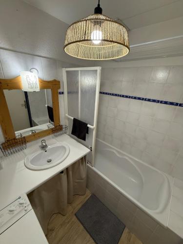 a bathroom with a sink and a tub and a mirror at T3 façon Chalet, terrasse et garage privé, Villard-De-Lans in Villard-de-Lans
