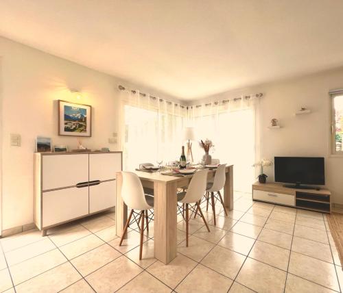 a kitchen and dining room with a table and chairs at Douce parenthèse moderne avec terrasse ensoleillée in Beaudreix