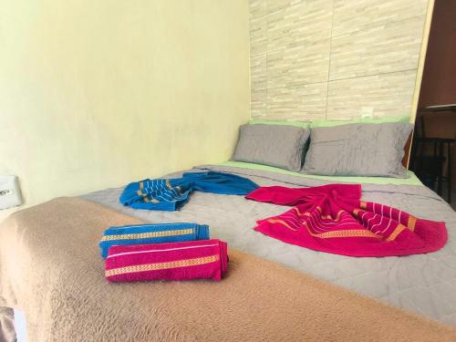 a bed with three towels on top of it at Casa Aconchegante - Arraial do Cabo a 5 minutos da praia in Arraial do Cabo