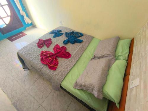 a bed with four bows on it in a room at Casa Aconchegante - Arraial do Cabo a 5 minutos da praia in Arraial do Cabo