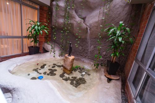 a bath tub in a room with plants in it at Suites House in Cali