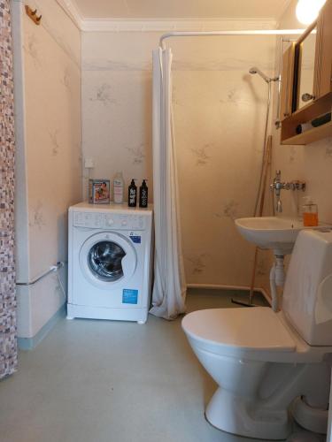a bathroom with a washing machine and a sink at Woxy Lilaloppan - privacy, space and nature in Voxnabruk