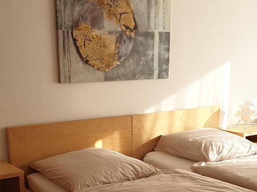 a bedroom with a bed and a painting on the wall at Apartments Im Sportpark in Weil am Rhein