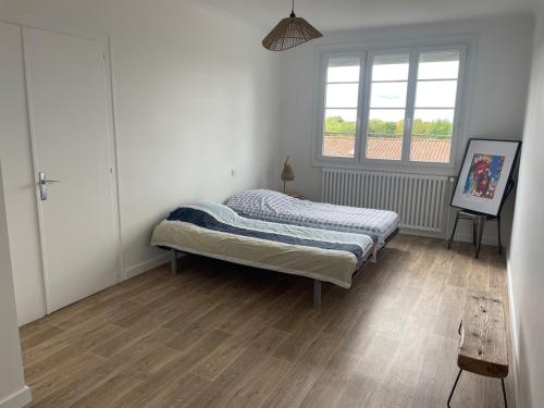 ein Schlafzimmer mit einem Bett und einem Fenster in der Unterkunft Farmhouse in Montaigu-Vendée