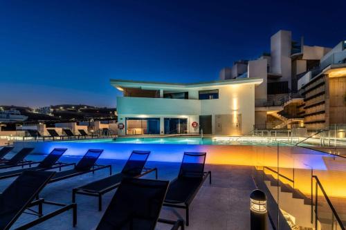 a swimming pool with chairs on a building at night at Luxury House at El Mirador Wellness, Hus 21 in Torrox Costa