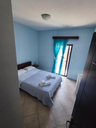 a bedroom with a bed with blue walls and a window at Villa Athamanio - Premium in Athamanio