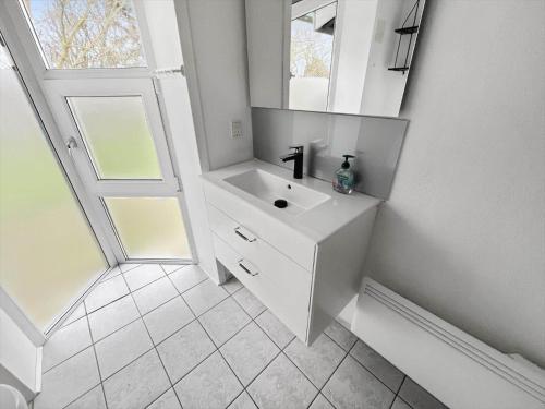 a white bathroom with a sink and a mirror at 0115-Romo-Lakolk-225 in Lakolk