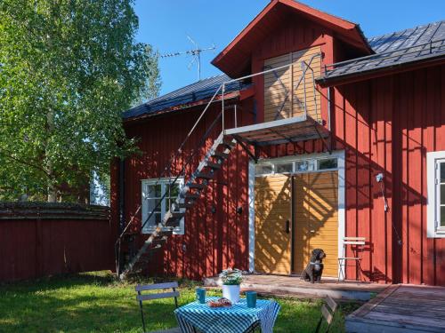 a dog sitting on the porch of a red house at Jädraås sjösida in Jädraås