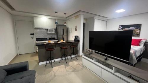 a living room with a large flat screen tv at studio guarulhos 1414 in Água Boa