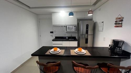 a kitchen with a table with two plates of oranges on it at studio guarulhos 1414 in Água Boa