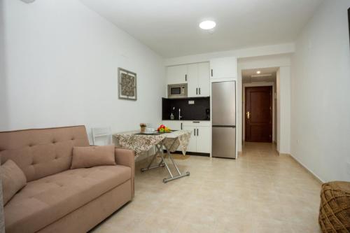 a living room with a couch and a kitchen at Brisa Marina Apartamento con vistas al mar in Mazagón