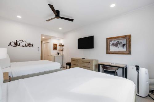 a bedroom with two beds and a flat screen tv at The Charter at Beaver Creek E135 in Beaver Creek