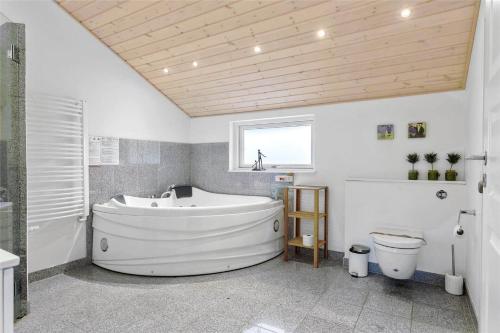 a large bathroom with a tub and a toilet at 0195-Romo-Smafolksvej-65 in Kongsmark