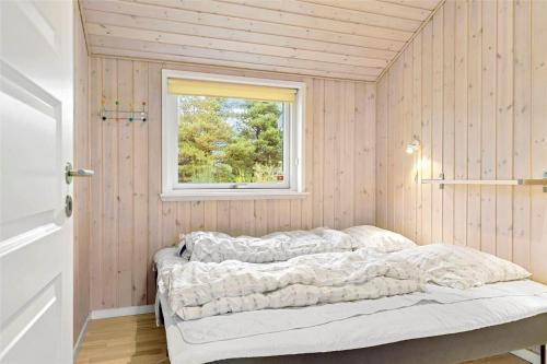 a bed in a room with a window at 0195-Romo-Smafolksvej-65 in Kongsmark