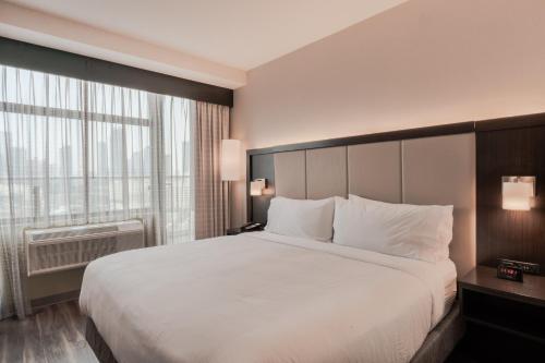 a bedroom with a large bed and a large window at Holiday Inn Express Long Island City E - New York by IHG in Queens