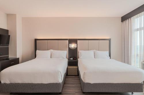 a hotel room with two beds and a tv at Holiday Inn Express Long Island City E - New York by IHG in Queens