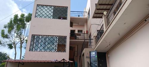 a tall white building with windows on a street at Tn27callingkrishholiday in Yercaud
