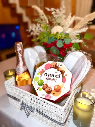 a basket with a bottle of alcohol and a candle at Landhaus AUSZEIT in Borod