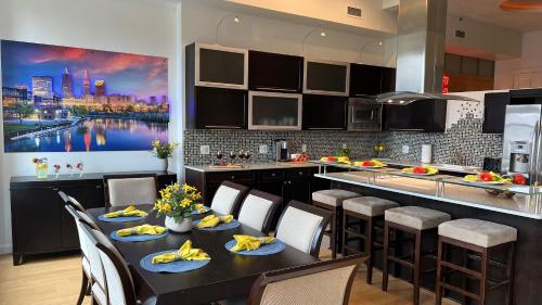 a kitchen with a table with chairs and a large painting at Downtown Cleveland- Steps to Sports & Events condo in Cleveland