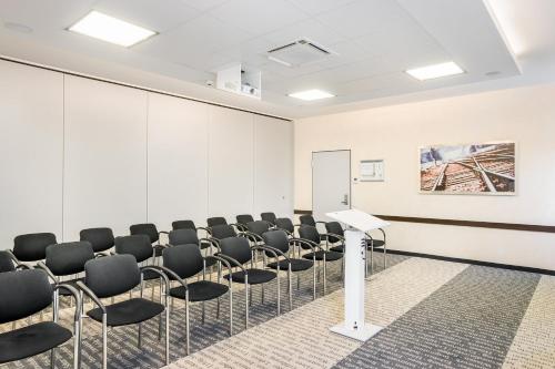 a conference room with chairs and a podium at Garner Hotel Oberhausen in Oberhausen