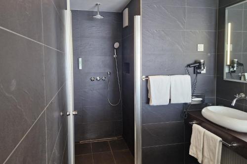 a bathroom with a sink and a shower at Garner Hotel Oberhausen in Oberhausen