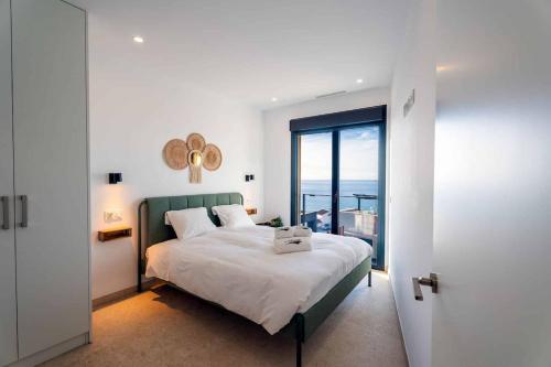 a bedroom with a bed and a large window at Luxury House in El Mirador Calaceite Torrox Costa, Hus 19 in Torrox Costa