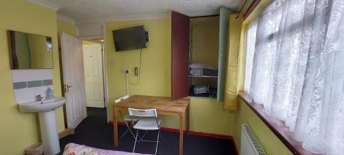 a small room with a desk and a sink and a window at Linda 5BR House Of Basildon in Basildon