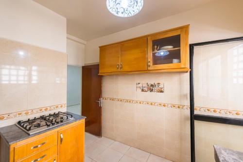 a kitchen with wooden cabinets and a stove top oven at Abd moulla Rouhi in Gare de Rabat-Aguedal
