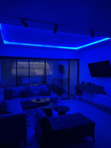 a blue room with a couch and a tv at Appartement marina hammamet in Hammamet