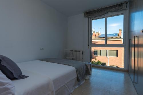 a bedroom with a bed and a large window at Montserrat Apartment in Callús