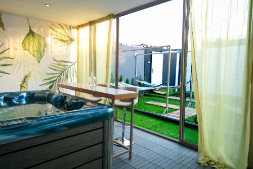a bathroom with a tub and a view of a garden at Maison à Skhirat Jacuzzi, jardin & proche plage in Skhirat