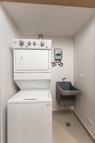 a small kitchen with a sink and a stove at Mar y Selva at Naumi, Ocean Views & Beach Club in Sardinal
