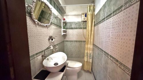een badkamer met een wastafel, een toilet en een spiegel bij Café de Baan Raow in Bangkok