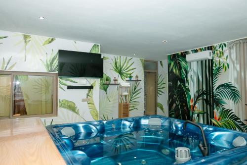 a blue tub in a room with plants on the wall at Maison à Skhirat Jacuzzi, jardin & proche plage in Skhirat