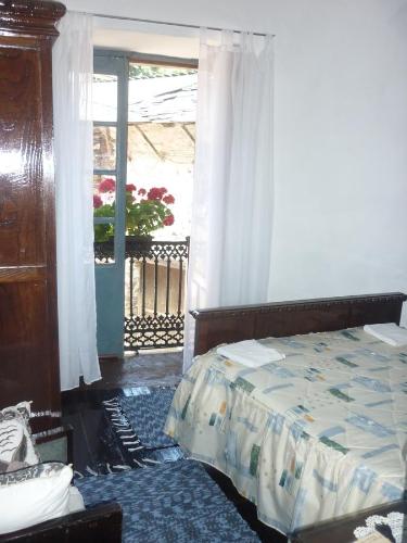a bedroom with a bed and a window at Pensión Santa Rosa in Samos