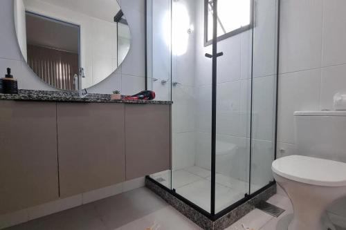 a bathroom with a shower and a toilet and a mirror at Studio Moderno no Ingá com Vista in Niterói