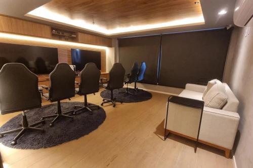 a conference room with chairs and a table and a screen at Studio Moderno no Ingá com Vista in Niterói