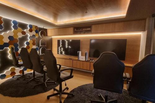 a conference room with chairs and a flat screen tv at Studio Moderno no Ingá com Vista in Niterói