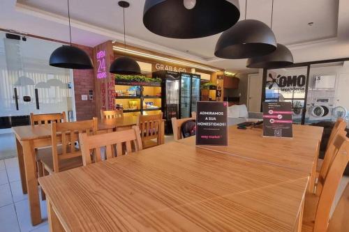 a restaurant with wooden tables and chairs and black lights at Studio Moderno no Ingá com Vista in Niterói
