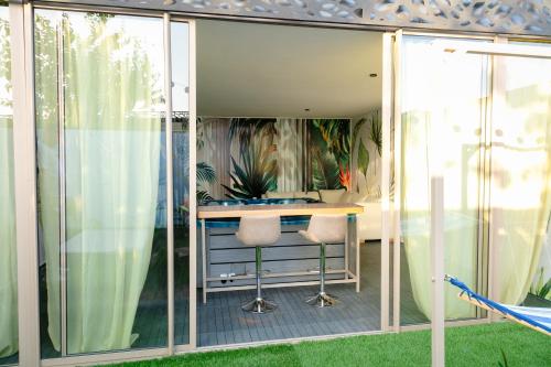 a home office with glass doors and a desk at Maison à Skhirat Jacuzzi, jardin & proche plage in Skhirat